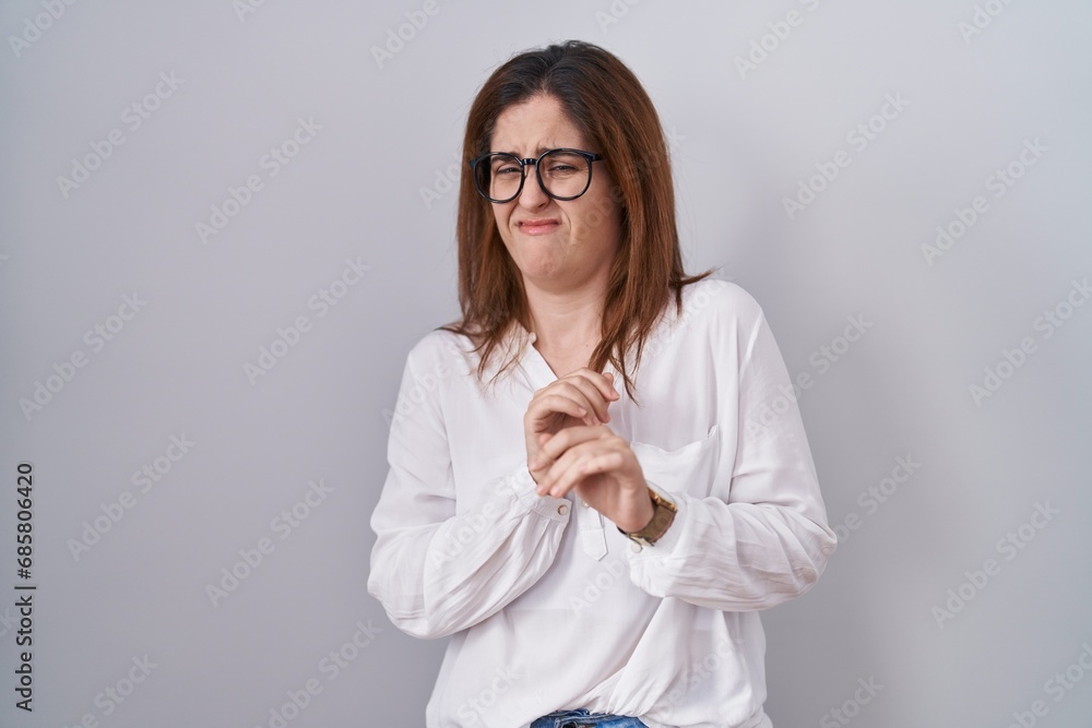 Brunette woman standing over white isolated background disgusted expression, displeased and fearful doing disgust face because aversion reaction. Brunette woman standing over white isolated background disgusted expression, displeased and fearful doing disgust face because aversion reaction.