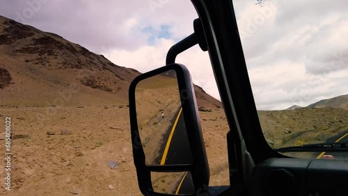 Rough terrain and roads visible in Rear View Mirror while Driving at Ladakh photo