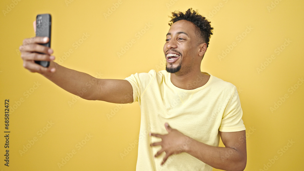 African american man smiling confident having video call over isolated yellow background African american man smiling confident having video call over isolated yellow background