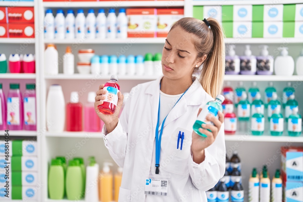 Young beautiful hispanic woman pharmacist smiling confident holding medication bottles at pharmacy