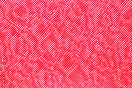 Seamless plastic texture background. Close-up of a detail from a red surface of a cosmetic bag. Beautiful backdrop. Macro.