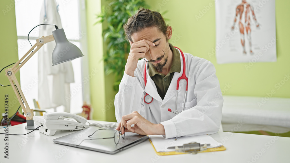 Young hispanic man doctor stressed at clinic Young hispanic man doctor stressed at clinic