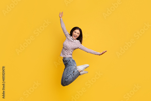 Foto Carefree joyful young asian woman jumping in the air