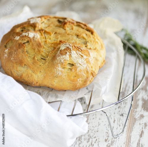 Round bread close-up. Freshly baked bread with a golden crust on bakery cooling rack..