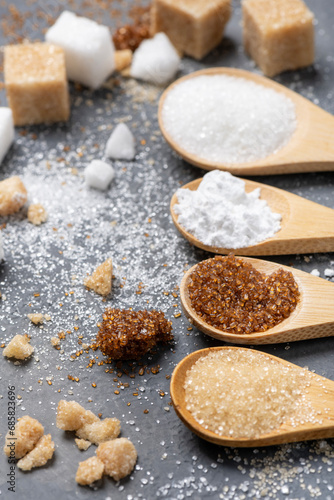 Various types of sugar in bamboo spoons, wholemeal, white and liquorice flavoured