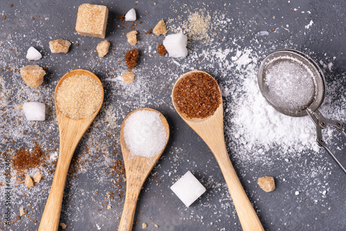 Various types of sugar in bamboo spoons, wholemeal, white and liquorice flavoured photo