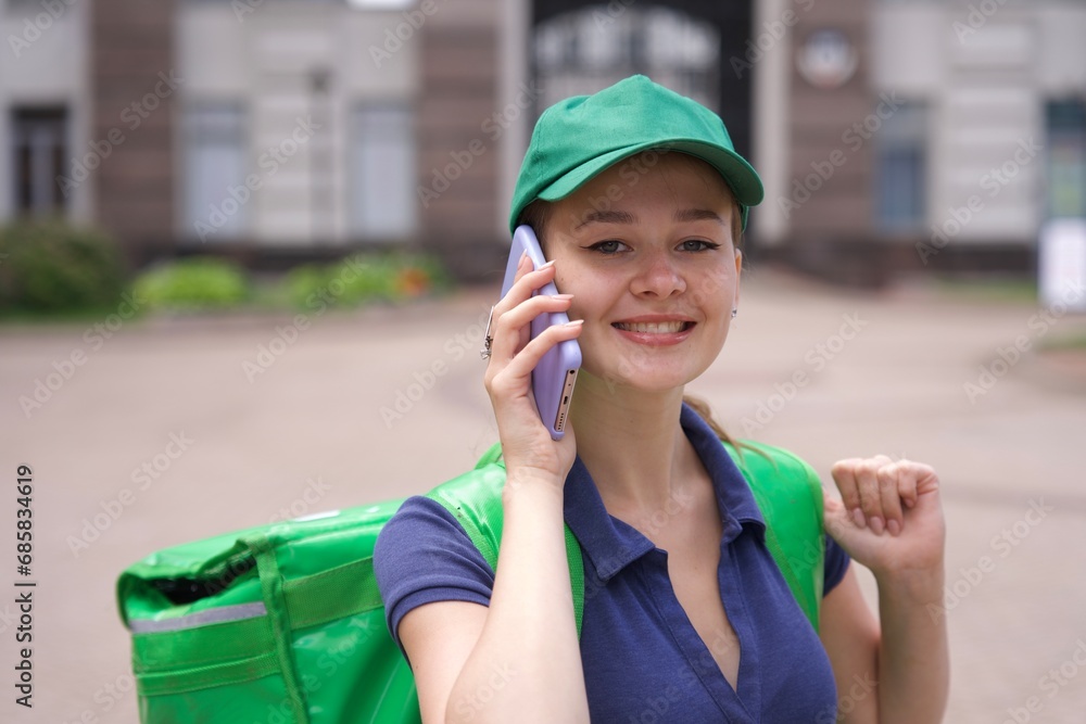 Happy young woman or teenager girl courier in green uniform with big ...