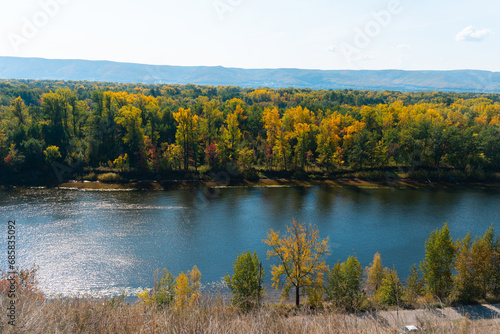 Top view from the mountain to the beautiful autumn forest and river