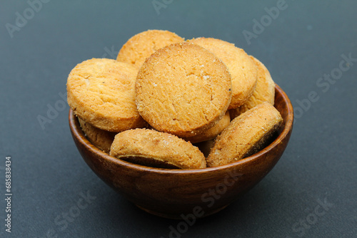 Osmania biscuits in a wooden bowl on black background close-up view 