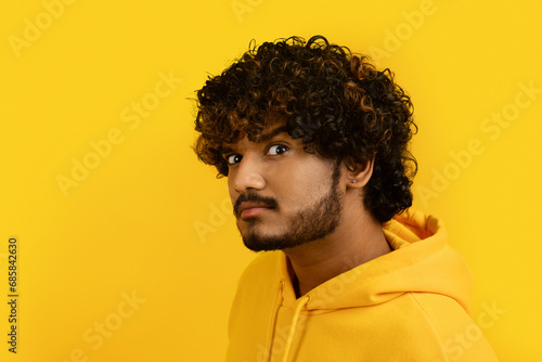 Young indian man 30s with suspicious look photo