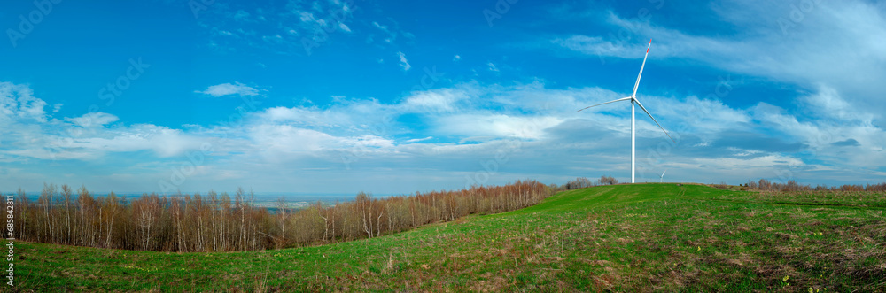 Naklejka premium Wind turbine for alternative energy in mountain landscape with clear space background. The concept of clean energy, eco-energetics of the wind.