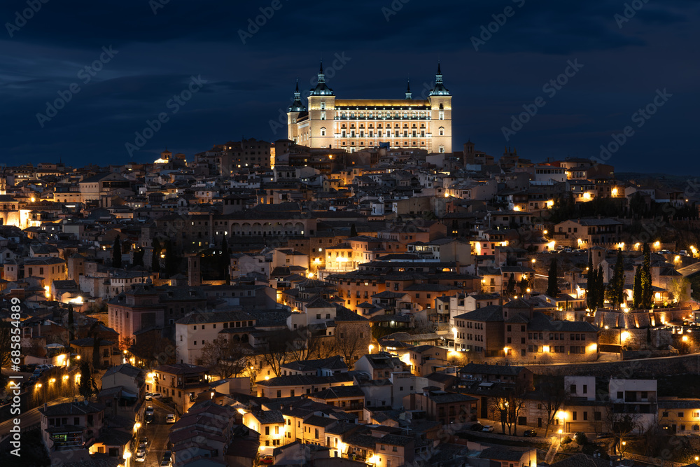 The historic center of Toledo, Spain, at night with the light of the streetlights and in the highest part, the Alcázar (nowadays the army museum) illuminated. UNESCO World Heritage Site