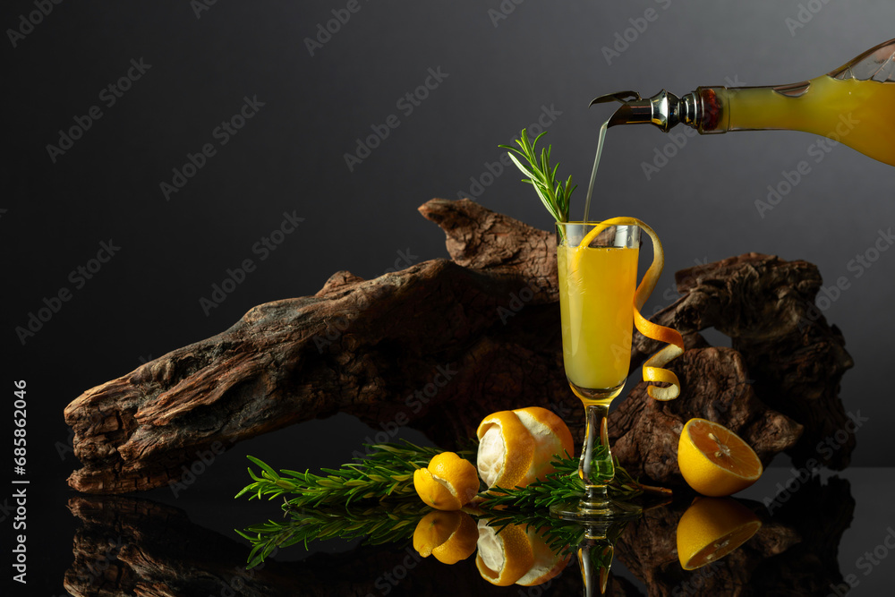 Traditional Italian liqueur Limoncello on a black reflective background. - obrazy, fototapety, plakaty 
