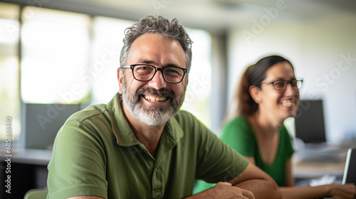 Smiling businessman sitting in front of team in the office during meeting © MP Studio