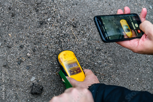 Measuring of the radiation level with dosimeter radiometer in Chornobyl exclusion zone photo