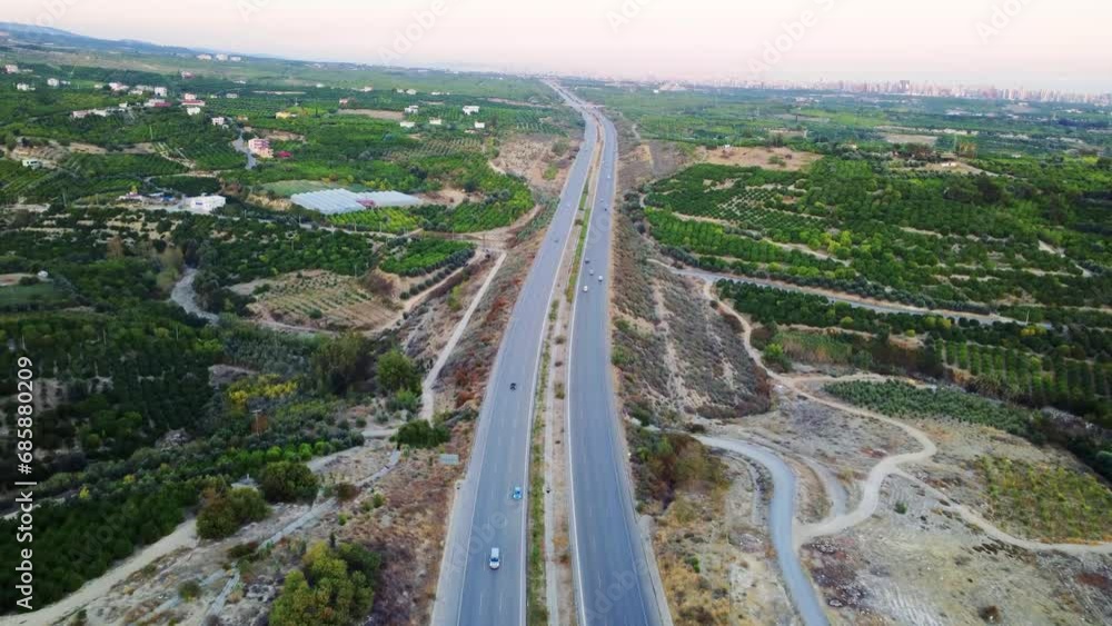 Drone captures motorway at sunset, traffic flowing smoothly. Motorway bathed in sunset, traffic creating dynamic patterns. Traffic moves along the motorway, sunset adding beauty to motion Drone captures motorway at sunset, traffic flowing smoothly. Motorway bathed in sunset, traffic creating dynamic patterns. Traffic moves along the motorway, sunset adding beauty to motion