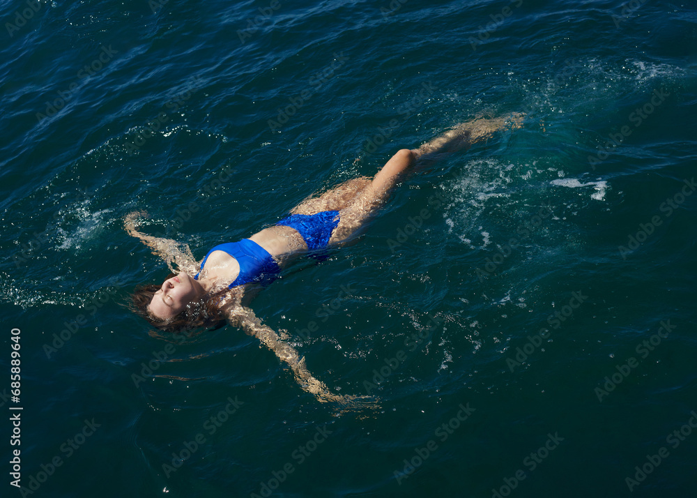 a happy woman enjoys her vacation by swimming in the sea