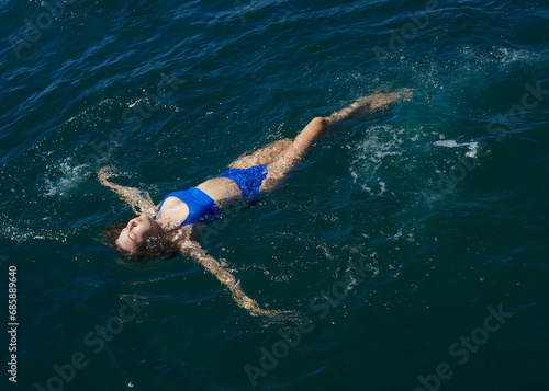 a happy woman enjoys her vacation by swimming in the sea