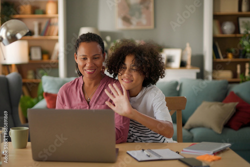 Mother and teenage son making video call on laptop at home