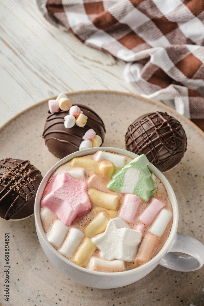 Chocolate bomb with cocoa powder and mini marshmallow to prepare a fragrant hot drink. On white wooden background. Chocolate bomb with cocoa powder and mini marshmallow to prepare a fragrant hot drink. On white wooden background.
