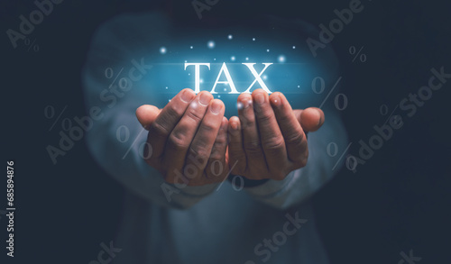 Businessman showing holographic tax on hand with percentage icon around, Concept of taxes paid by individuals and corporations, Business process, income tax and property history tax, VAT. photo