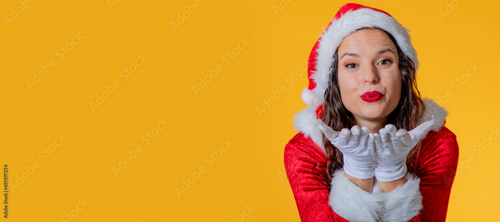 isolated girl in santa claus hat blowing a kiss