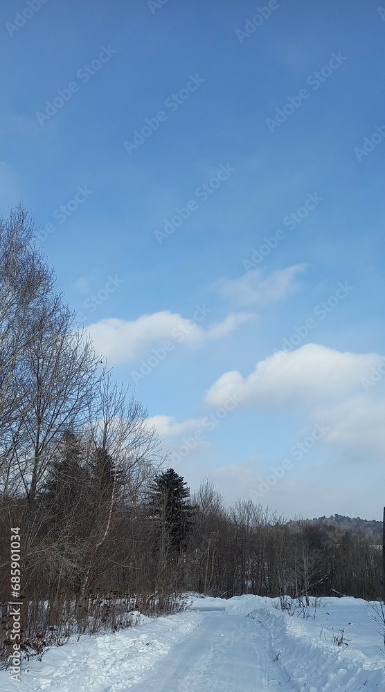 winter landscape, snow-covered road, beautiful clouds against the blue sky, winter season winter landscape, snow-covered road, beautiful clouds against the blue sky, winter season