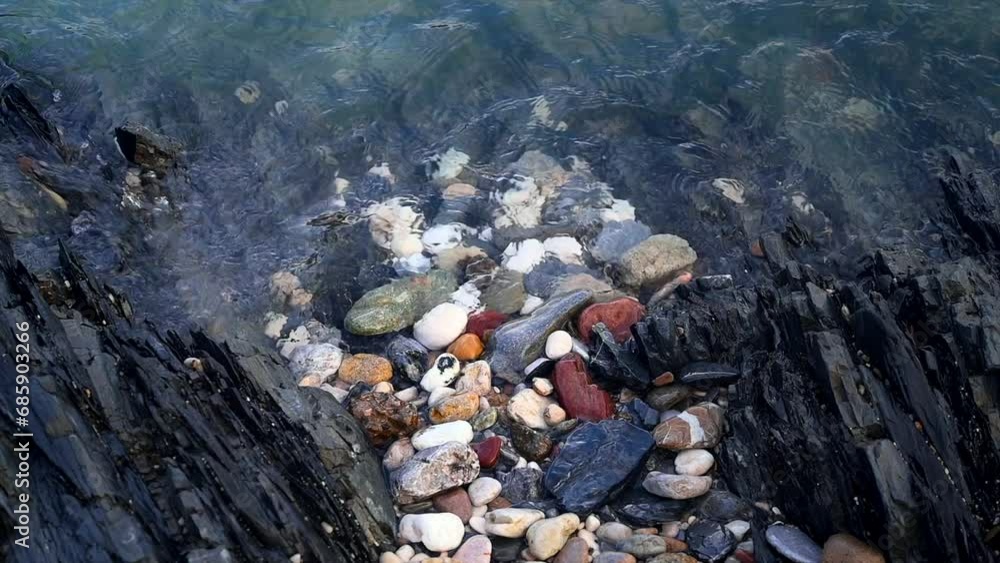 Small rock in a mountain river. Gray stone layers and small coastal waves. Small rock in a mountain river. Gray stone layers and small coastal waves.