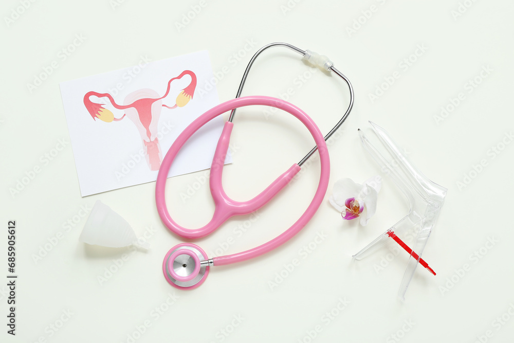 Gynecological speculum, drawing of female uterus, menstrual cup and stethoscope on white background Gynecological speculum, drawing of female uterus, menstrual cup and stethoscope on white background
