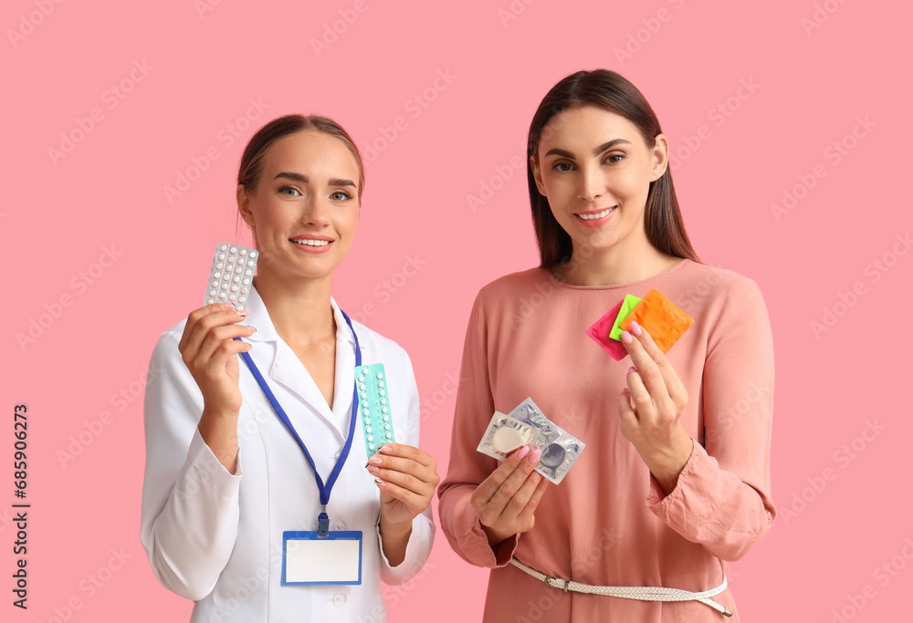 Female gynecologist and patient with contraceptives on pink background Female gynecologist and patient with contraceptives on pink background