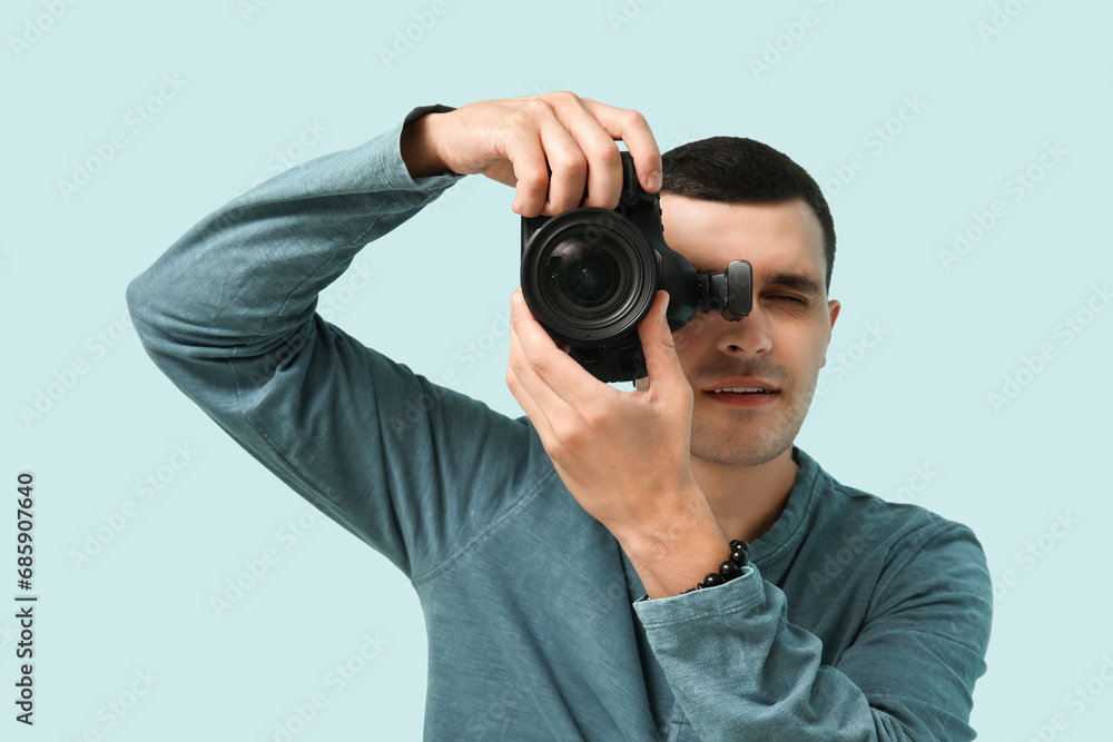 Male photographer with modern camera on light background Male photographer with modern camera on light background