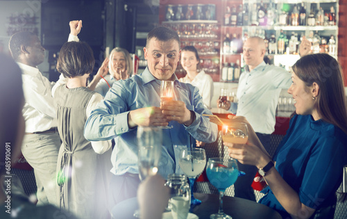 Portrait of cheerful tipsy businessman drinking alcohol and having fun at corporate party in nightclub photo