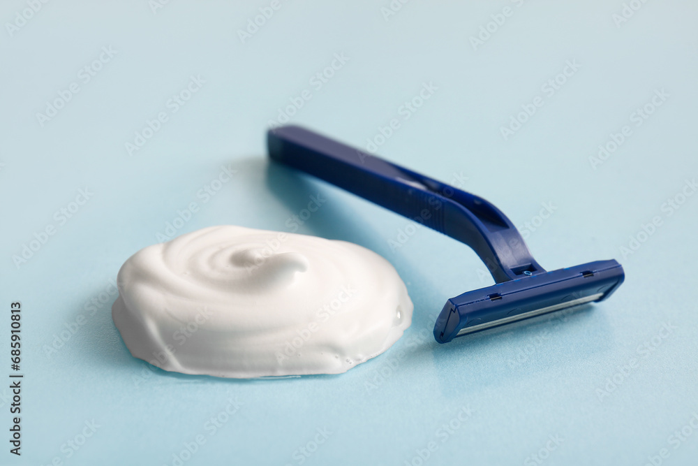 Razor and shaving foam on blue background Razor and shaving foam on blue background