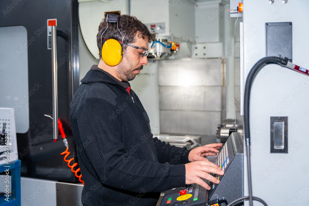 Fototapeta premium Factory worker coding in CNC modern machine