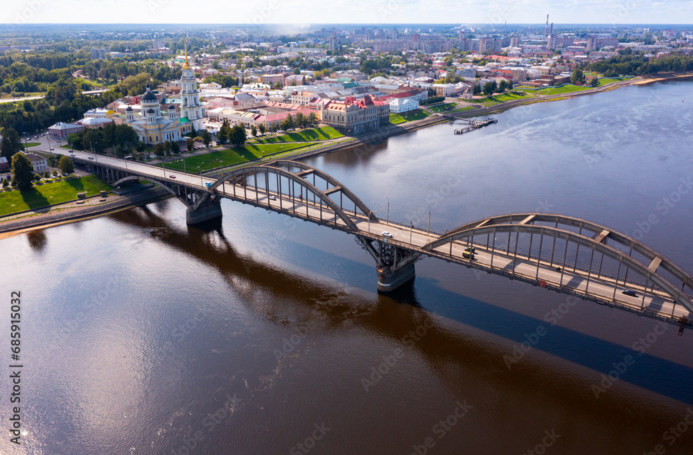 Drone view of the small Russian city of Rybinsk with the longest and original bridge over the Volga River on a summer day