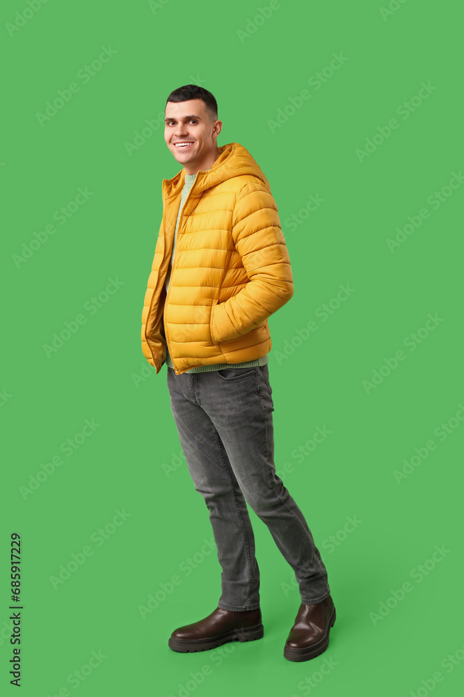 © Pixel-Shot - Young man in yellow stylish puffer jacket on green background © Pixel-Shot - Young man in yellow stylish puffer jacket on green background