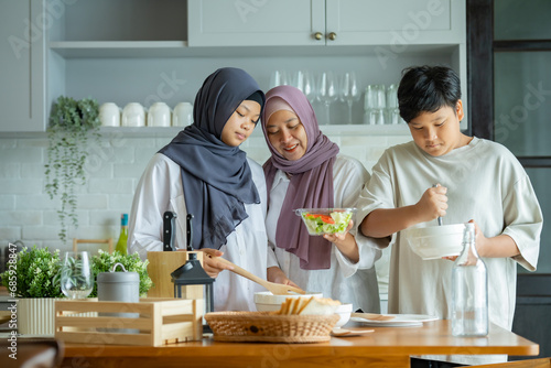 Cute Girl and Son and Her Muslim Mom In Hijab Preparing Pastry For Cookies In Kitchen, Baking Together At Home. Islamic Lady With Daughter and son Enjoying Doing Homemade Pastry