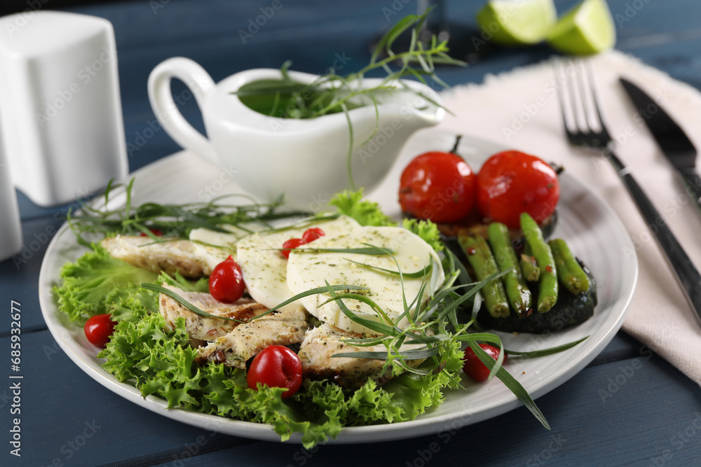 Tasty mozzarella, chicken and vegetables with tarragon served on blue wooden table, closeup Tasty mozzarella, chicken and vegetables with tarragon served on blue wooden table, closeup