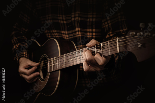 アコースティックギターを弾くミュージシャン