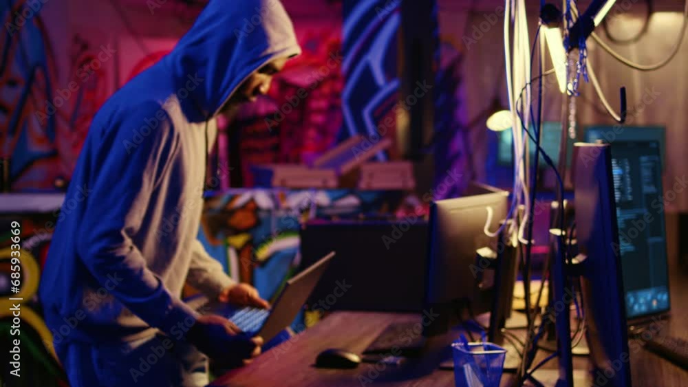 Hacker arriving with laptop in hidden base, deploying viruses on unaware victims computers, stealing sensitive and private information, selling it on darknet black market to highest bidder Hacker arriving with laptop in hidden base, deploying viruses on unaware victims computers, stealing sensitive and private information, selling it on darknet black market to highest bidder
