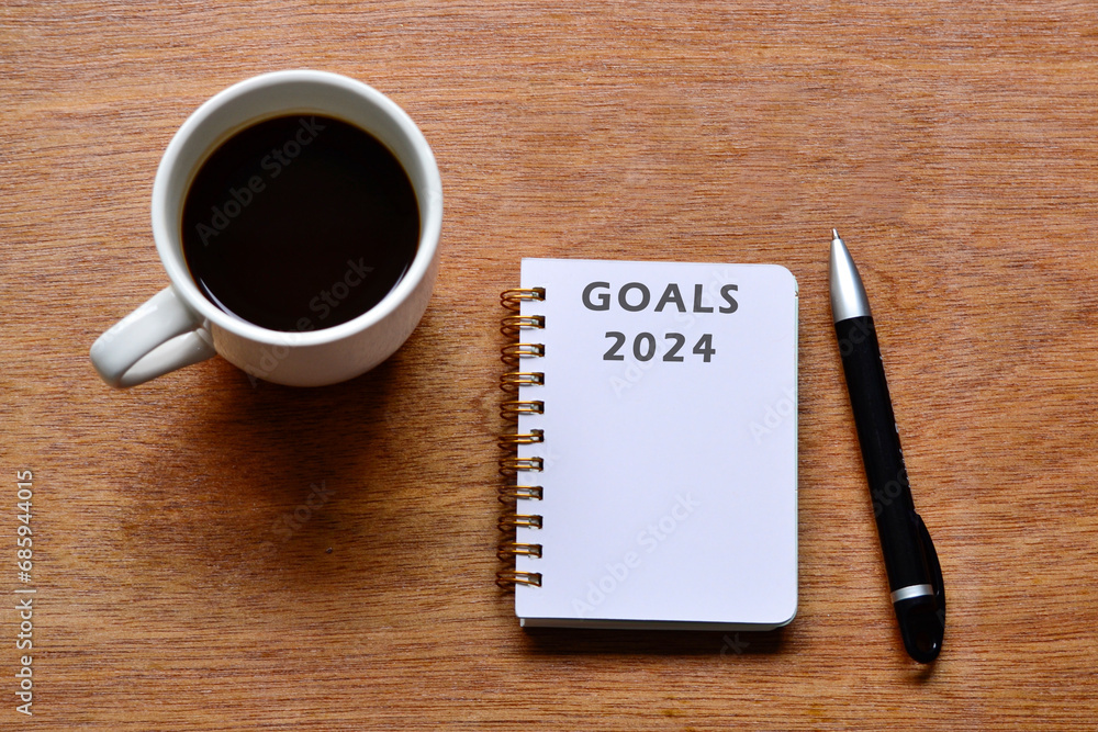 Goals 2024 text on notepad with coffee and pen on wooden desk. Goals 2024 text on notepad with coffee and pen on wooden desk.
