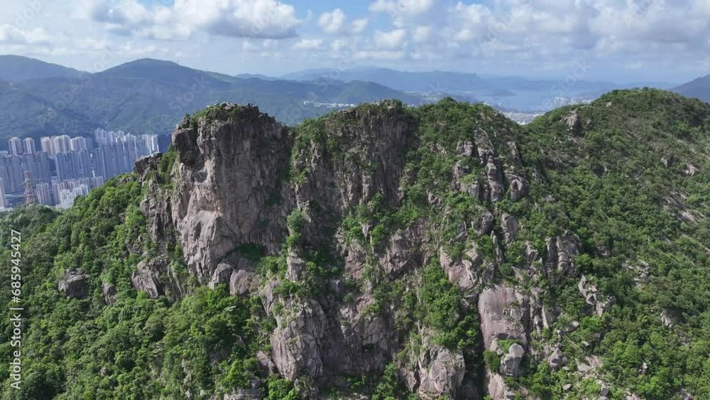 Lion Rock mountain in Kowloon Peninsula Hong Kong sunny aerial drone skyview shot. Popular travel destination in Asia. China. Rock climbing cliffs Lion Rock mountain in Kowloon Peninsula Hong Kong sunny aerial drone skyview shot. Popular travel destination in Asia. China. Rock climbing cliffs