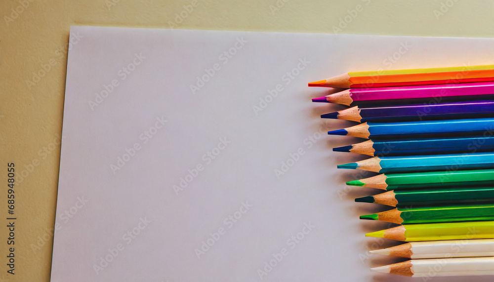Obraz premium White paper and colorful colored pencils, top view