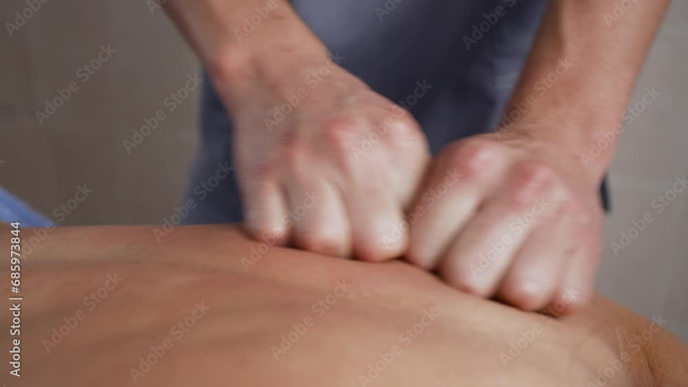 Close-up of a woman relaxing during a back massage while lying on a massage table. Close-up of a woman relaxing during a back massage while lying on a massage table.