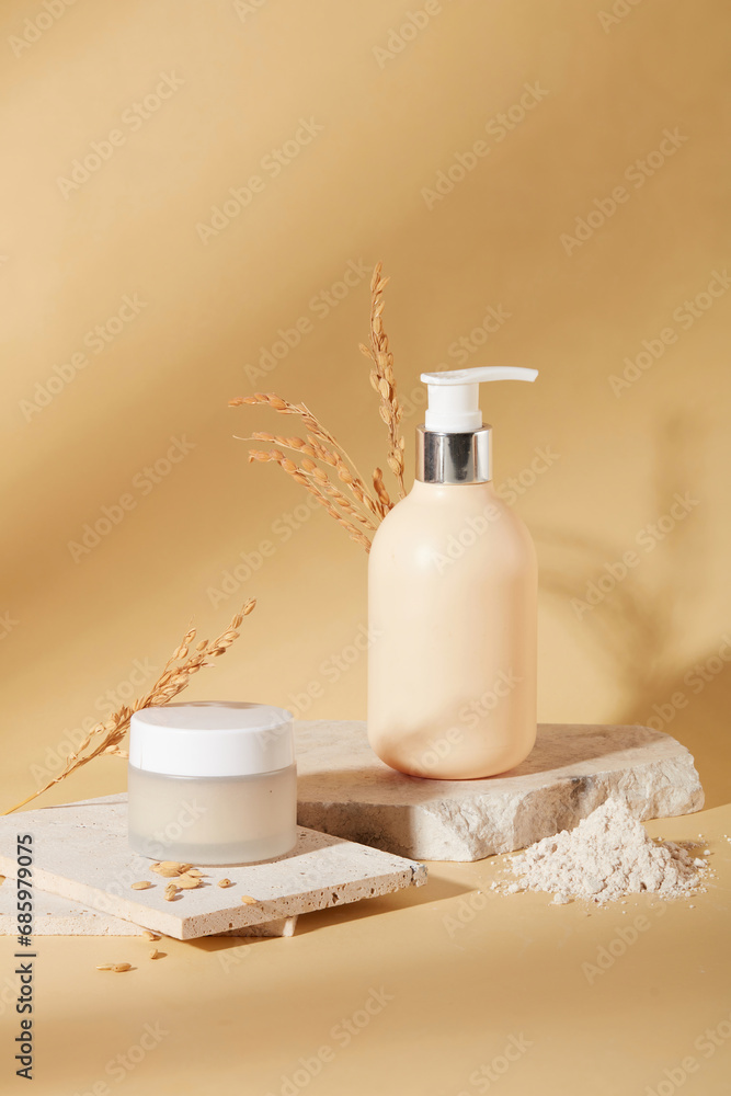 Front view of a jar of lotion and a bottle of shower gel are placed on a podium with rice bran powder on a beige background. Skin care with natural ingredients. Front view of a jar of lotion and a bottle of shower gel are placed on a podium with rice bran powder on a beige background. Skin care with natural ingredients.