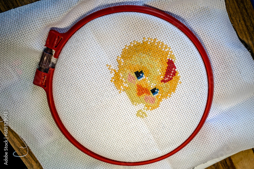 Foto Unfinished embroidery with colored threads on fabric close-up