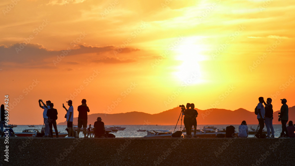 Fototapeta premium People enjoyed capturing sunset at the beach.