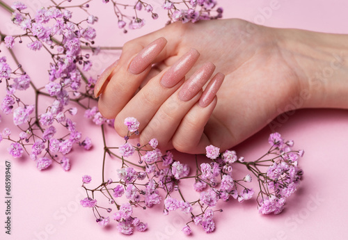 Female hands with beautiful manicure on pink background