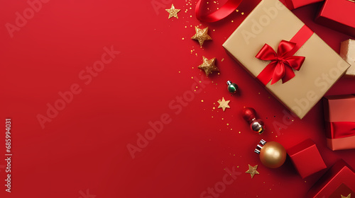 Celebrate holidays in style. Top view of gift boxes featuring red and gold embellishments, Christmas tree ornaments, confetti, all arranged on festive red surface with empty space for your message