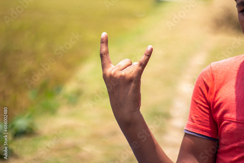 A man pointing two fingers of his hand upwards and blurred background © Rokonuzzamnan
